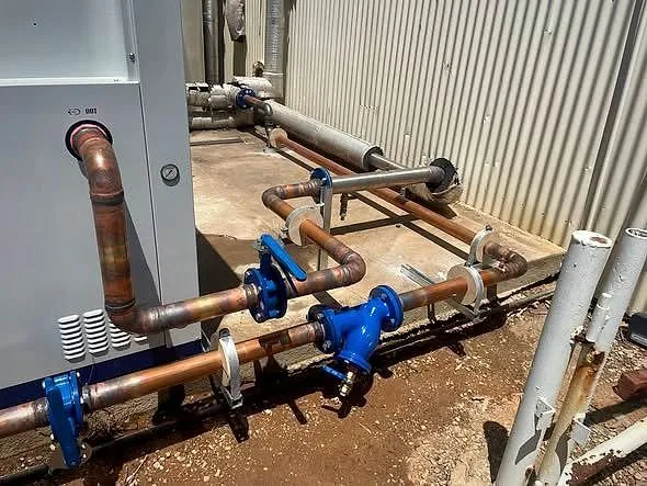 Copper pipework and blue valves on a unit, fitted by Classic Air and Mechanical Services